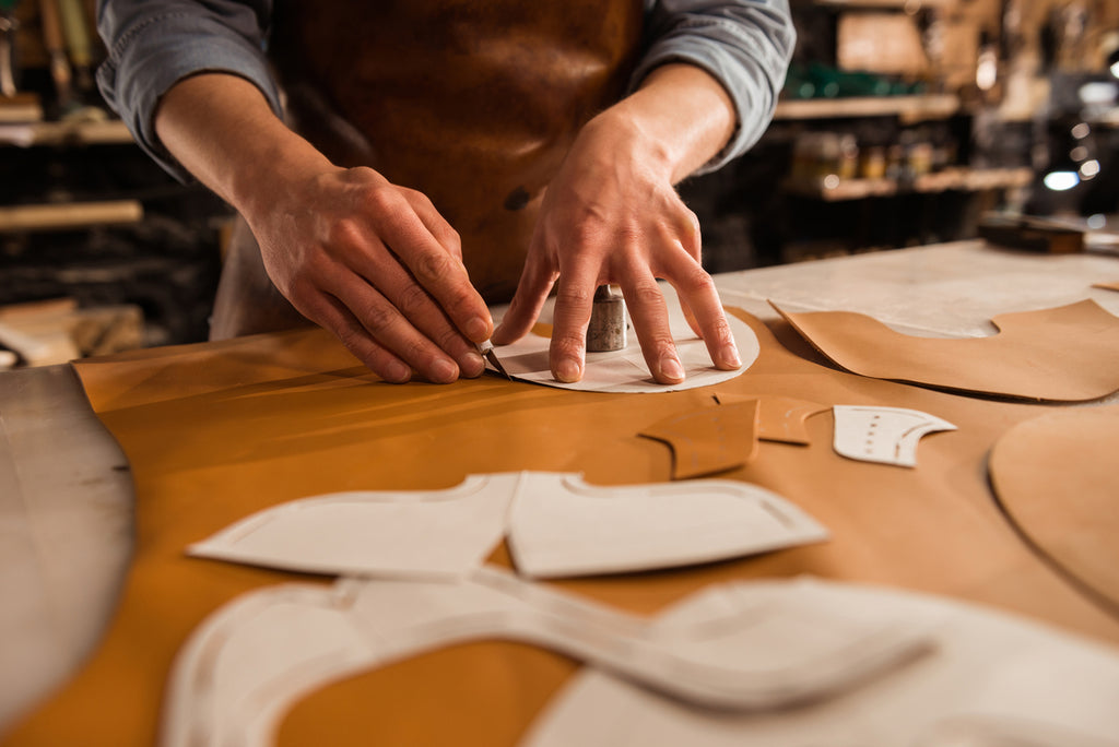 male shoemaker cutting leather