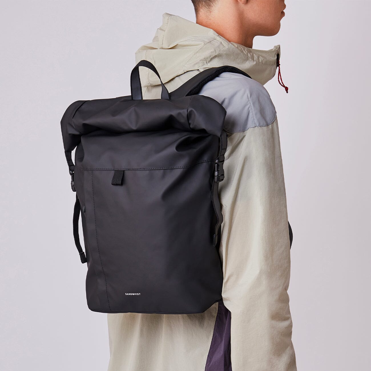 man model wearing small waterproof backpack recycled polyester roll top konrad sandqvist black