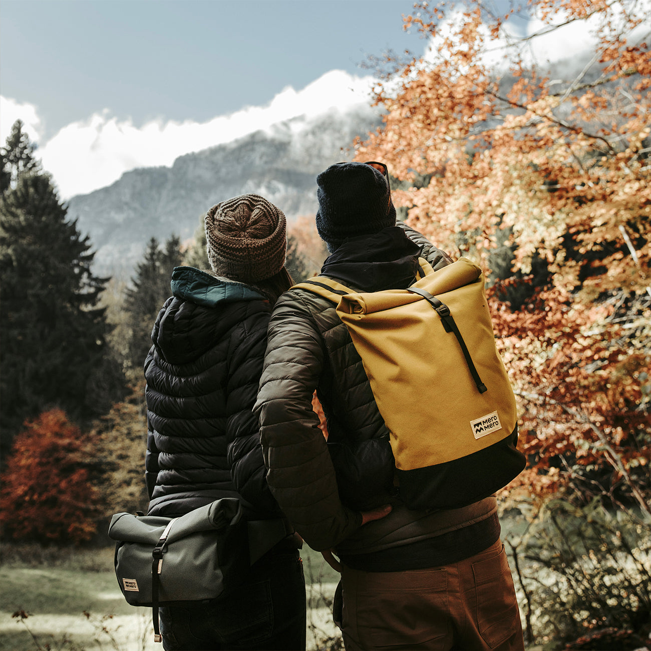 couple en randonnée dans la forêt portant un sac à dos de randonnée écologique de ton jaune, modèle de chez mero mero