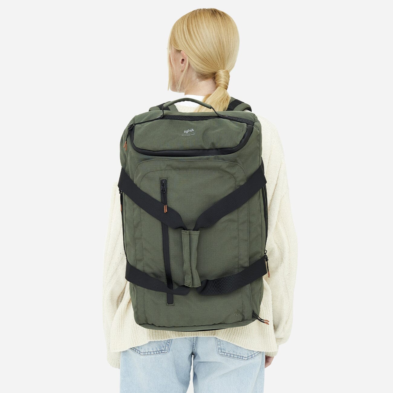Woman wearing green eco-friendly convertible backpack, back view