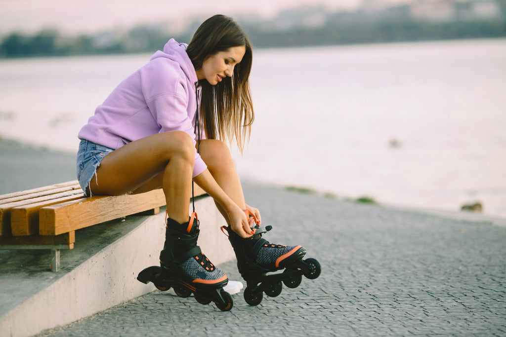 Jeune femme séduisante avec des patins à roulettes dans un parc