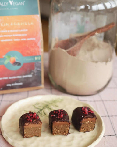 Image of double layered protein bars with protein powder in the background