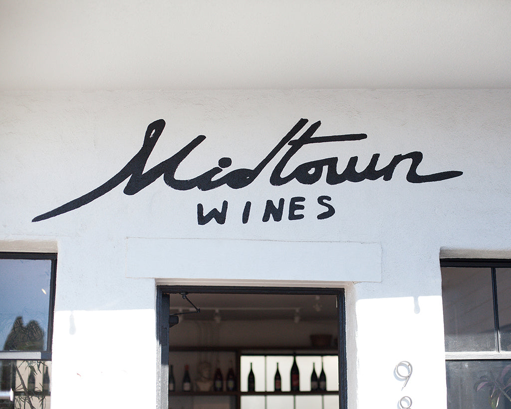 picture of a hand painted sign on a building that says "Midtown Wines"