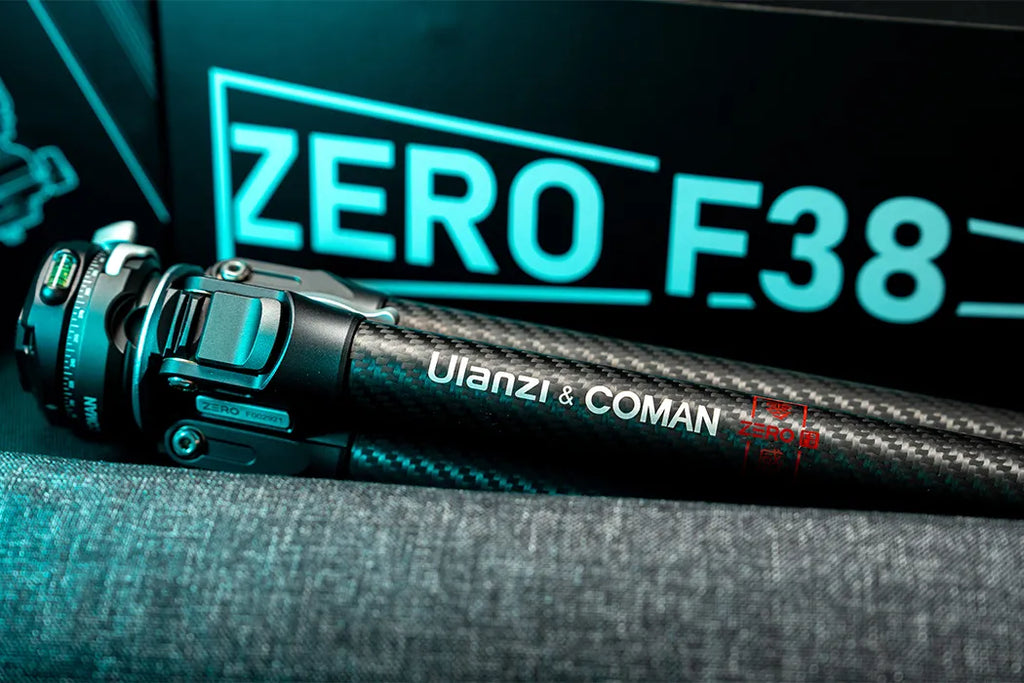 A close-up shot of a carbon fiber tripod leg, featuring the "Ulanzi & COMAN" branding and a quick-release mechanism, set against a dark background with the glowing text "ZERO F38."