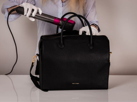 drying the inside of a purse with a hairdryer