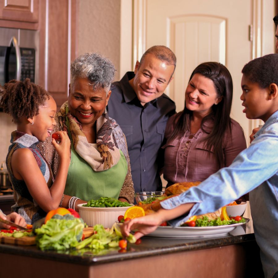 Diverse family at home, hanging out in the kitchen cooking their Thanksgiving dinner.