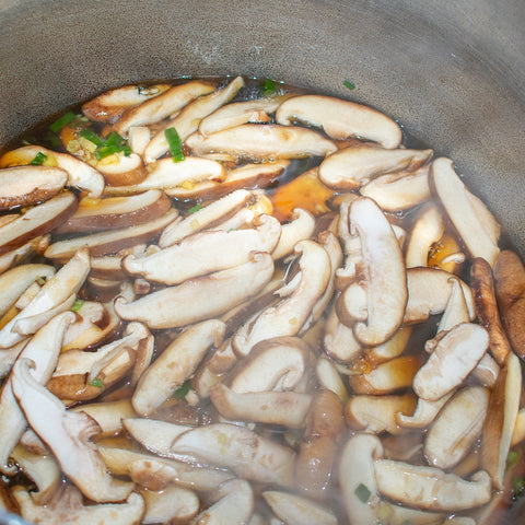 sliced shitake mushrooms in broth