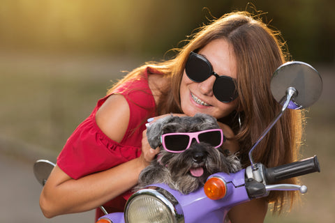 cheerful-girl-with-dog-sunglasses-lilac-moped-concept