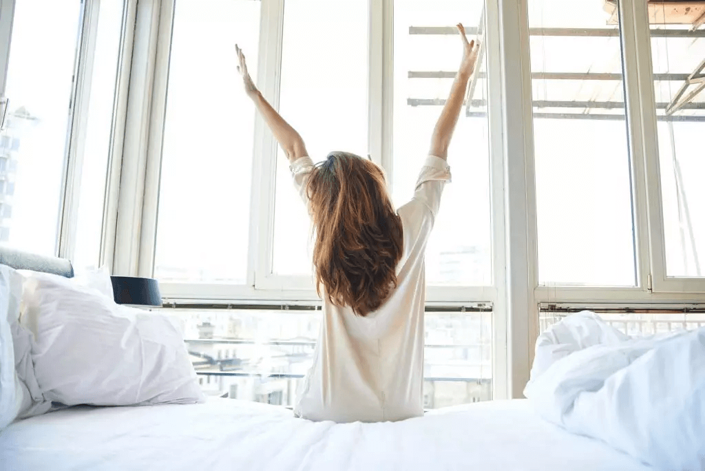 woman getting out of bed after a good night's sleep from melatonin and cbd