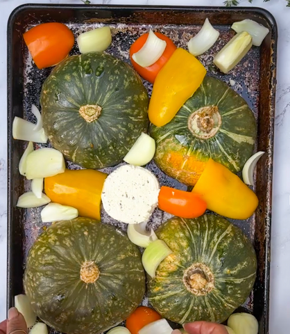 buttercup squash, onions and carrots on a roasting dish to make soup
