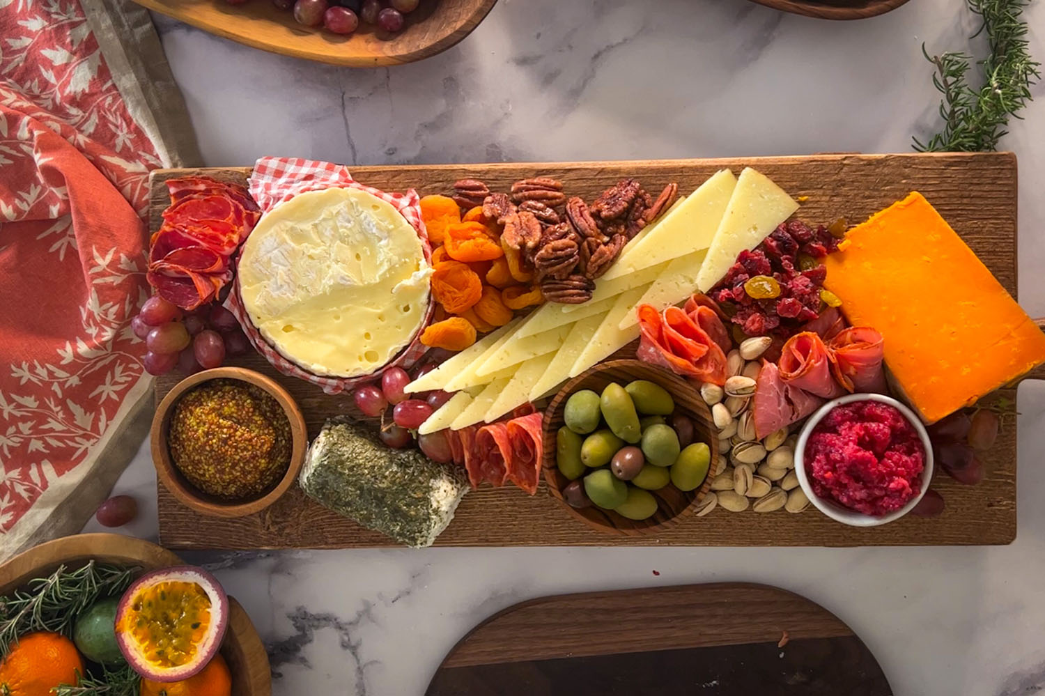 Charcuterie board with dips, olives, grapes, cheeses, folded meats, dried fruits and nuts