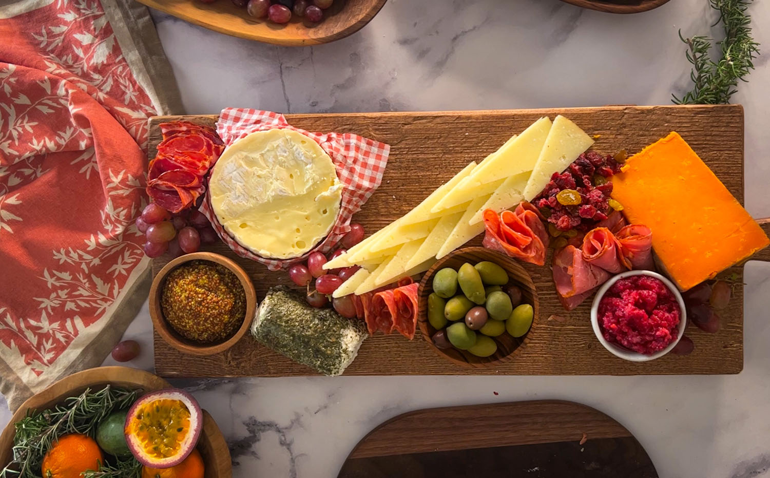 Charcuterie board with dips, olives, grapes, cheeses, and folded meats
