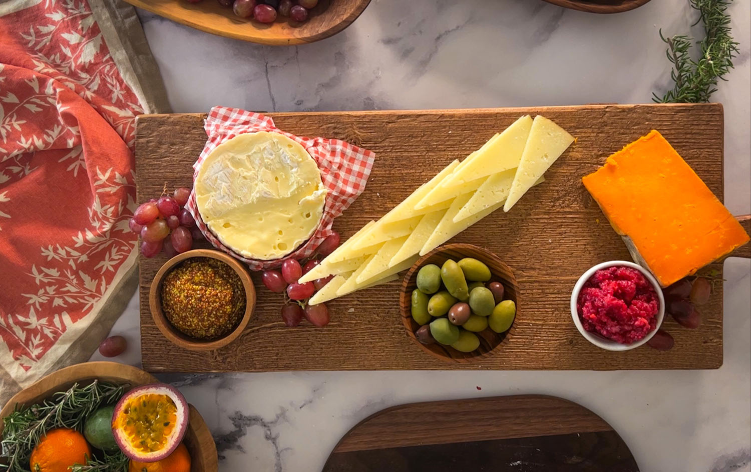 Charcuterie board with olives, dips, grapes, and cheeses