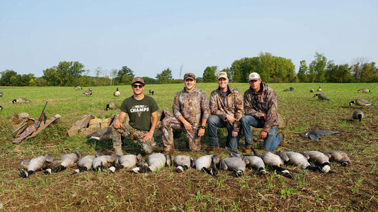 a group of hunters sit behind their goose