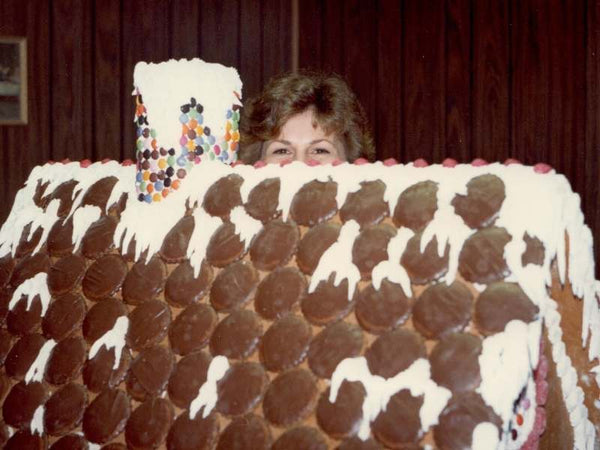 Janet (Nona) hiding behind a huge ginger bread house.