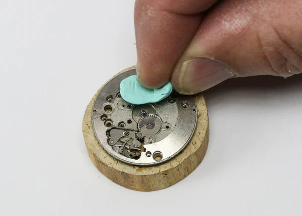 watchmaker cleaning a watch movement with rodico cleaning putty