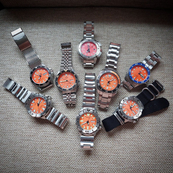 a collection of multiple watches with orange dials