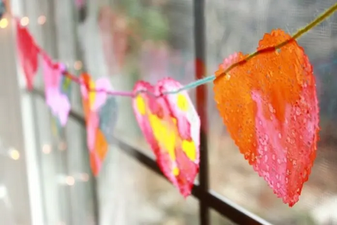 Painted paper hearts strung across a window