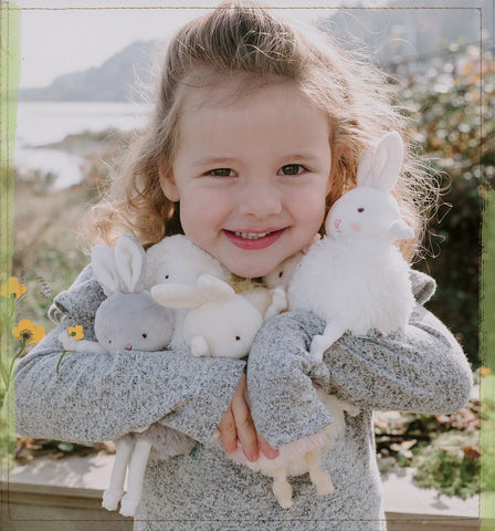 Little Girl Holding Stuffed Bunnies