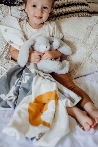 Little Girl Snuggling With Stuffed Bunny and Blanket