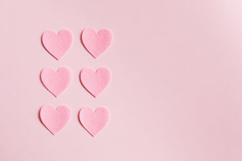 Pink cut out hearts on a pale pink background
