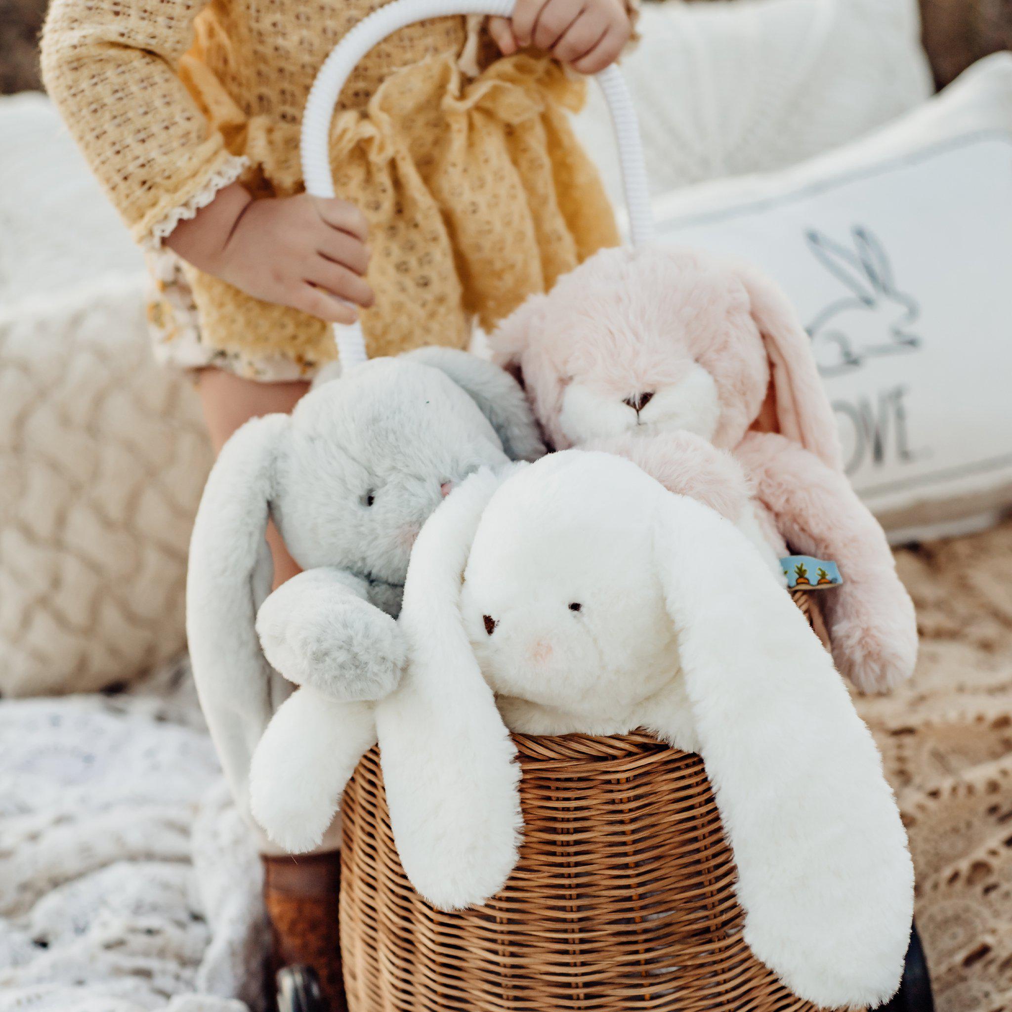 A bunch of plush bunnies pulled on a cart by a toddler