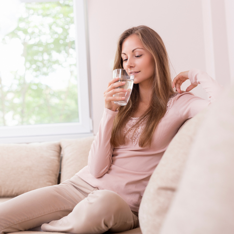 woman on sofa drinking water