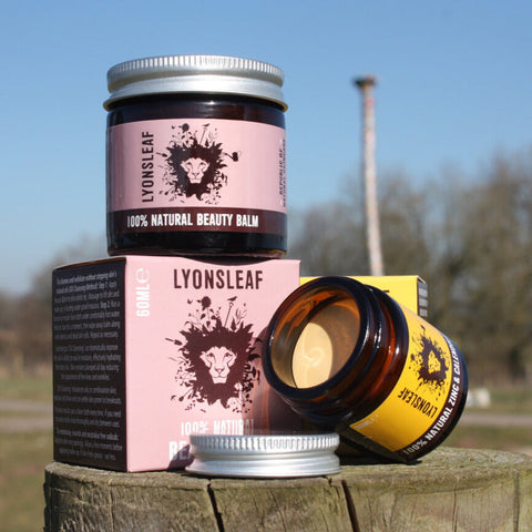 lyonsleaf skincare products on top of a tree trunk with fields, trees and blue skies in the background