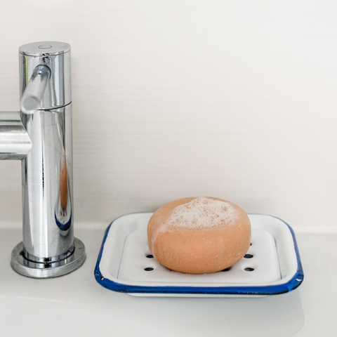 silver tap with shampoo bar or white and blue metal soap dish