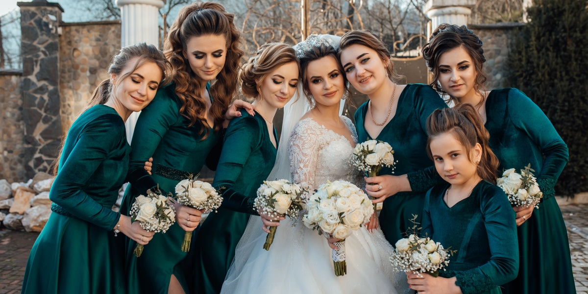 Beautiful and elegant bride with her friends. Bride with bridesmaids. Girlfriends in emerald dresses. Photo of the bride and bridesmaids.