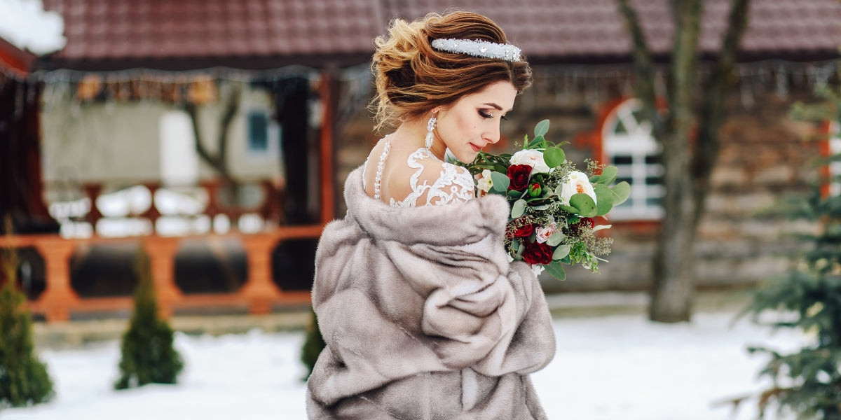 Beautiful bride with a bouquet is standing with her back.