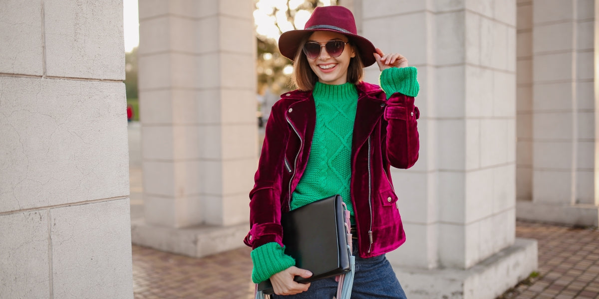 cute woman in autumn style trendy outfit walking in street wearing purple velvet jacket, sunglasses and hat, green knitted sweater, holding handbag, smiling happy, season strend