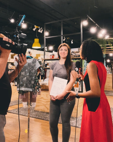 Two women on a news interview, standing inside a local store full of handmade goods in Spokane, Washington