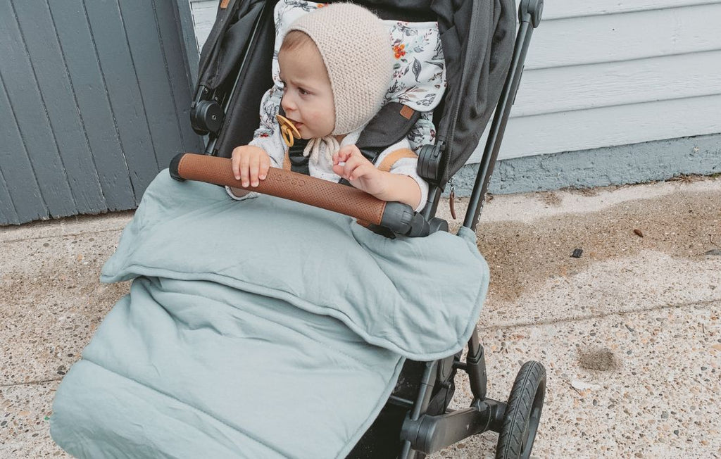 baby in pram with pram quilt