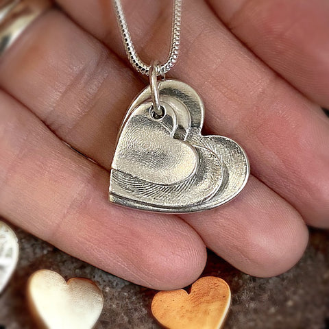 mother holding personalised fingerprint necklace, triple childrens fingerprint jewellery