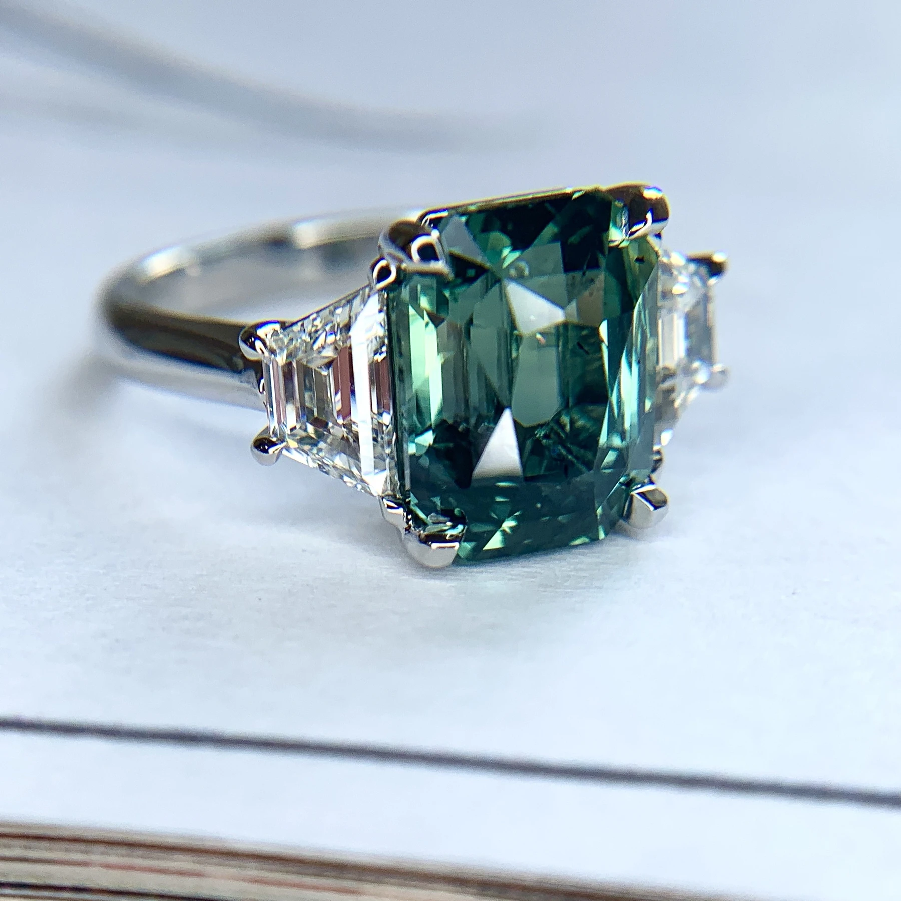Green sapphire emerald cut engagement ring with diamond accents