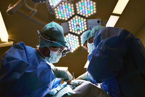 Dos cirujanos realizando prácticas de sutura en un paciente.