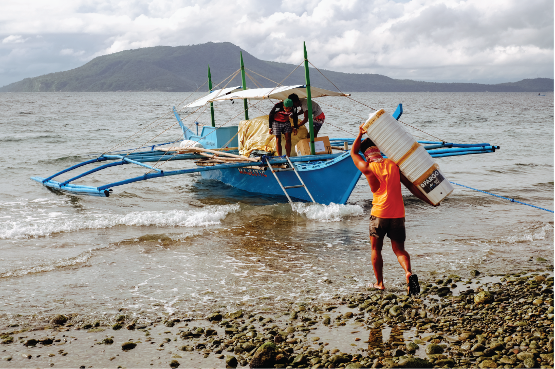 Man in Indonesia loading sustainable clean water filters onto boat