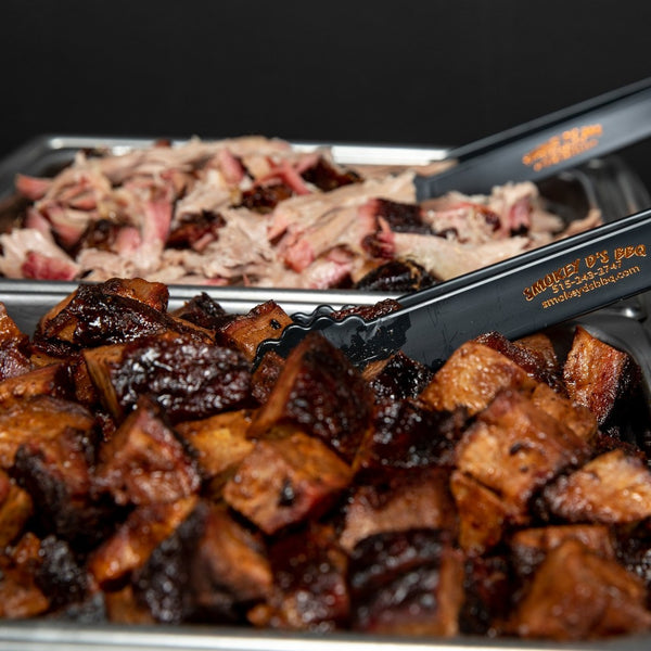 tongs grabbing for bbq meats during a catering event by smokey d's bbq in des moines