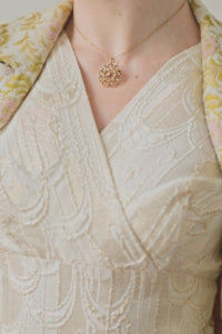 Vintage gold brocade dress with Edwardian pearl and diamond sunburst necklace.