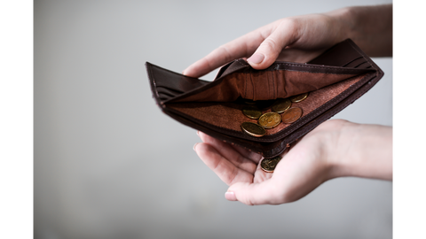 Hands empty change out of a brown leather wallet