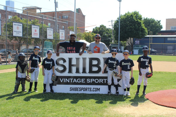 Reef and Johnny unveil the Shibe outfield sign before the U10 Homecoming game 