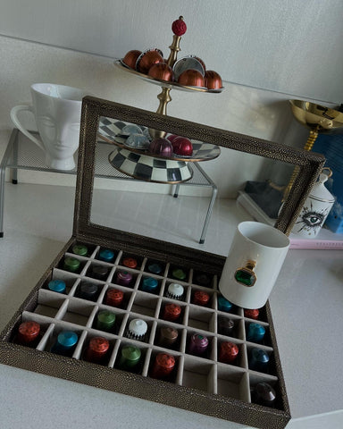 Una caja de polipiel con cristal en la parte superior y con divisiones para guardar las cápsulas de nespresso o joyería