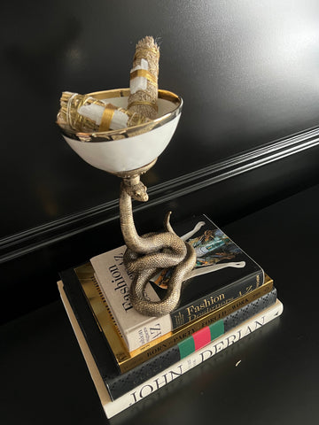 Accesorio decorativo para el hogar de un plato hondo blanco con especias aromáticas sobre una base de serpiente