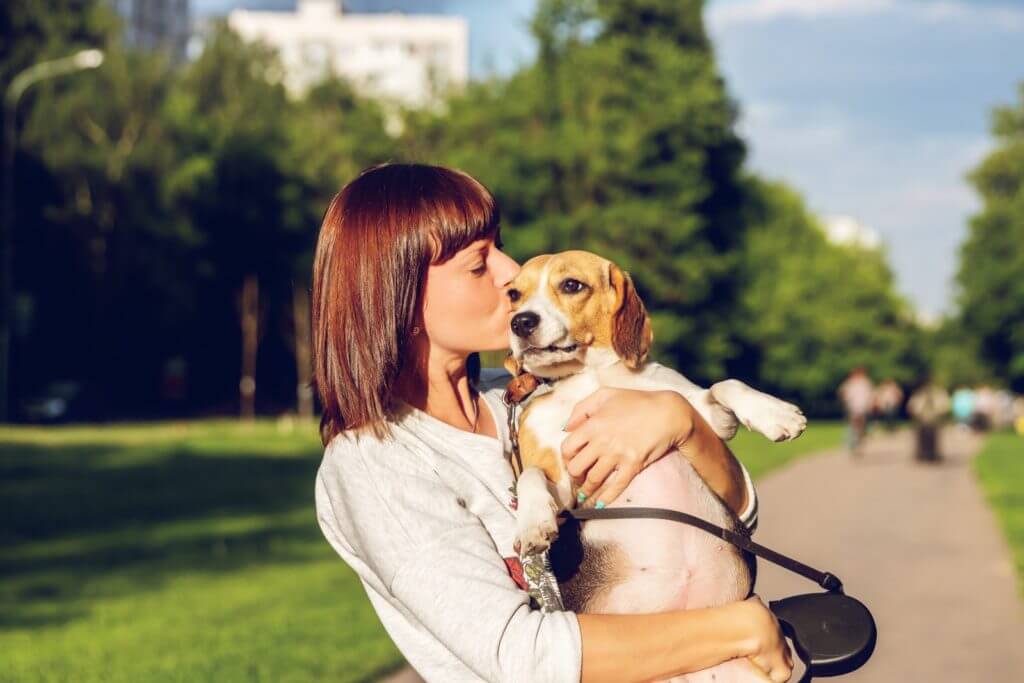 woman holding her puppy outside