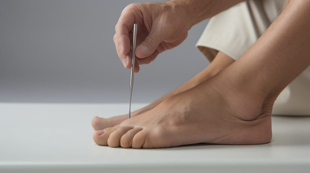 image showing a close-up view of a foot with a doctor using a tuning fork to test for sensory loss on specific areas