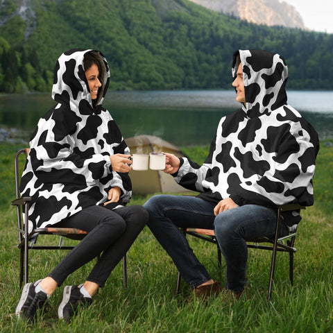 man and women driking coffee in their cow print snug rug hoodies