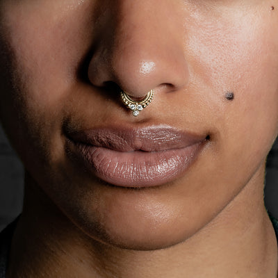 Close-up of model wearing septum clicker ring