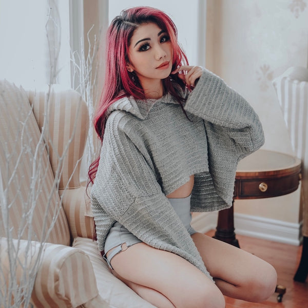 buttercream crop knit sweater and grey strap shorts on red hair model sitting down