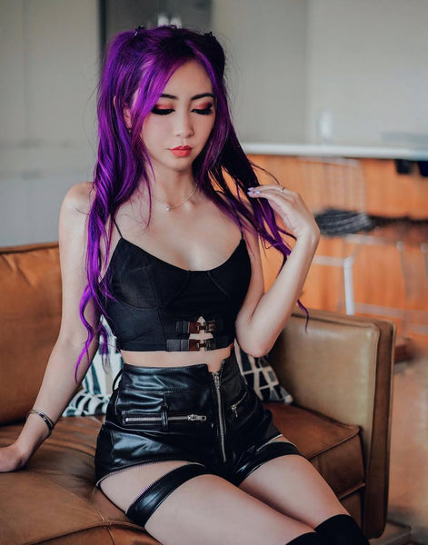 first rave wear outfit of purple hair model wearing a black bustier and pleather shorts